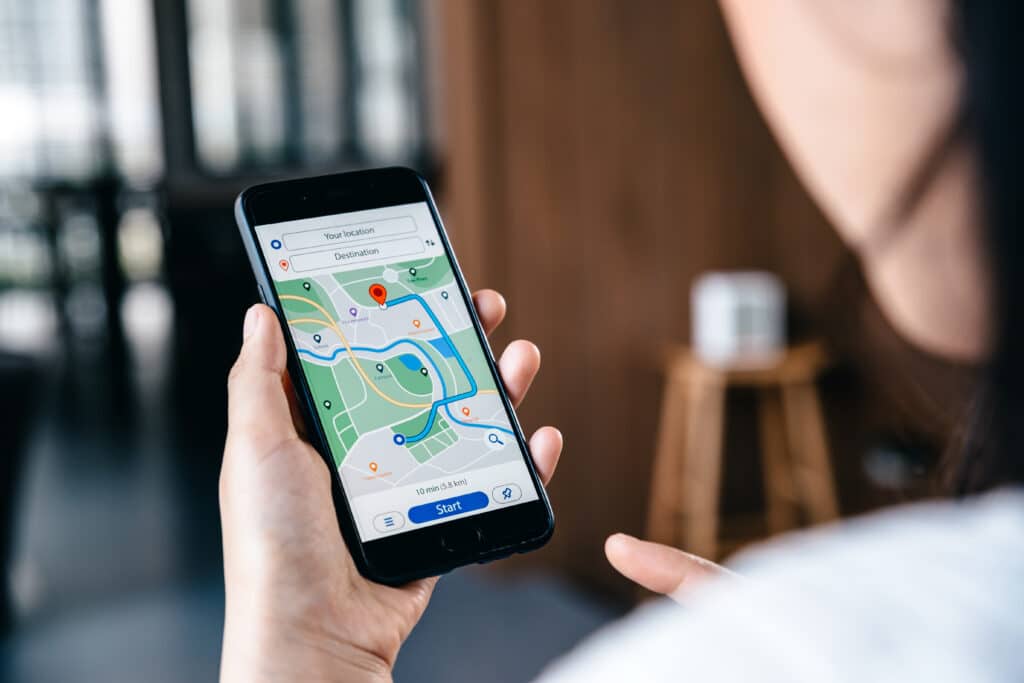 HeartBeep Marketing NH Intent Based Marketing, Hand of young woman searching location in map online on smartphone, Online navigator and travel concept.