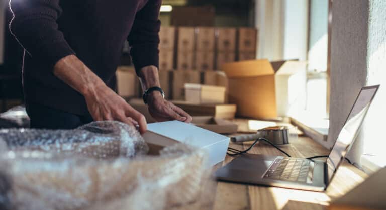 HeartBeep Marketing NH ecommerce SEO Manchester, Small business owner packing in the cardbox at workplace. Cropped shot of man preparing a parcel for delivery at online selling business office.